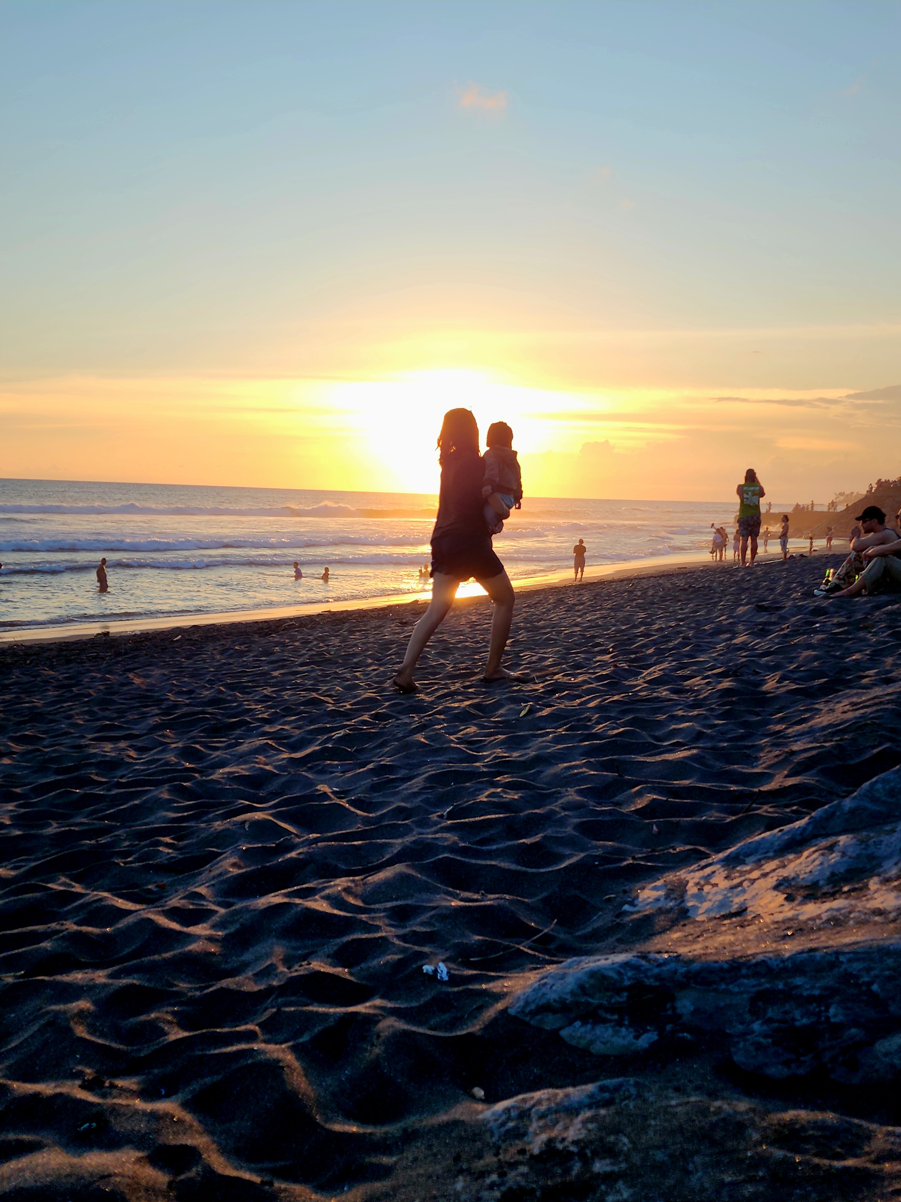 Parent and child together at the beach at sunset